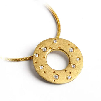 A 18ct gold necklace with a textured, circular pendant adorned with brilliant cut diamonds, attached to a gold chain.