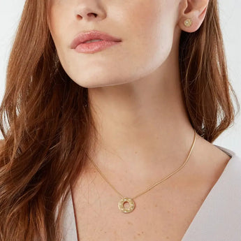A set of 18ct gold jewelry including a necklace with a circular pendant adorned with sparkling diamonds, and a pair of earrings, both featuring a frosted finish.