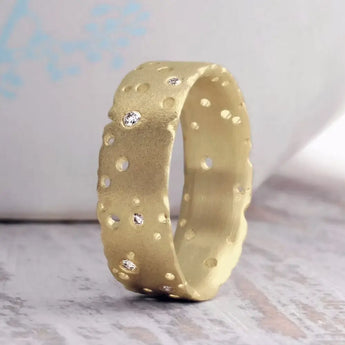 A 9ct gold diamond ring with a textured finish and scattered brilliant cut diamonds set throughout, displayed against a light background.