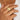 A close-up image of a person's hand wearing a wide gold ring with diamond accents on the finger.