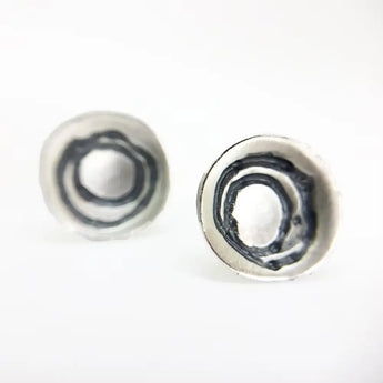 A pair of sterling silver earrings with spiral etched design on a white background.