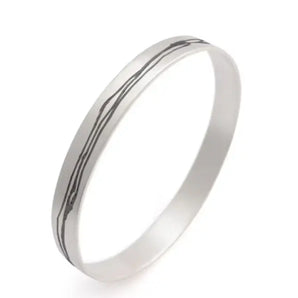 A silver bangle bracelet with an etched, textured design.