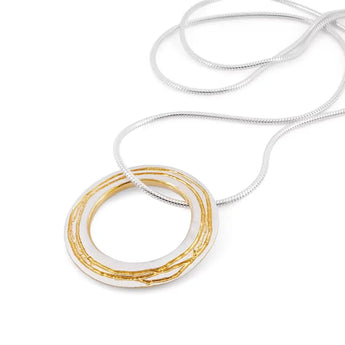 A sterling silver necklace with a gold detailed pendant, featuring a chain link and etched design, on a white background.