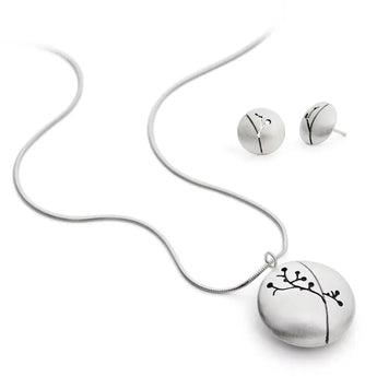 A silver necklace with a floral silhouette pendant accompanied by a pair of matching earrings, displayed against a white background.