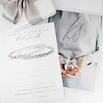 Gift voucher for Kate Smith Jewellery Design with a silver bracelet and a person holding a gift box.