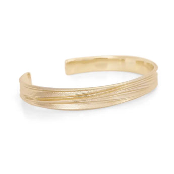 A gold cuff bracelet with a textured matte finish, displayed against a white background.