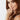 Woman with long brown hair and a ring on her finger against a white background