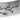 Close-up of a silver cuff bracelet with hand engraved floral patterns and a satin finish.