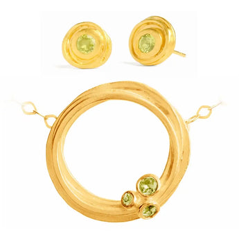 A set of gold-plated sterling silver jewelry, featuring a large swirl pendant necklace and a pair of earrings with green peridot stones.