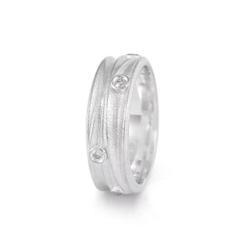 A silver ring with a textured finish and scattered diamonds set on an angle, showing the inside of the ring which is polished and smooth.