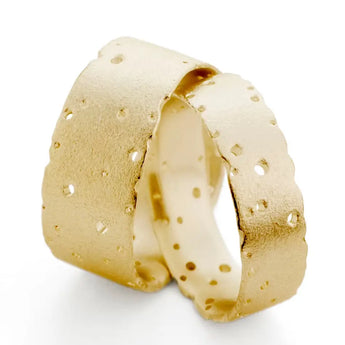 A patterned wedding ring in 18ct yellow gold with nibble detailing, displayed against a white background.
