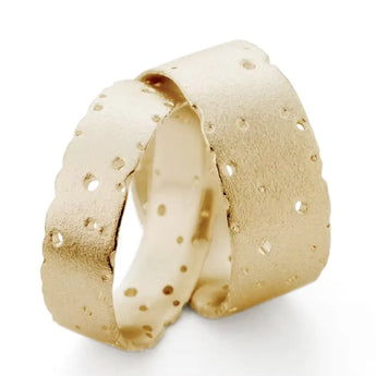 A unisex 9ct gold wedding ring with nibbled edges and drilled detailing, displayed against a white background.