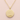 A gold round pendant necklace with a textured finish and a small 'KS 375 €' hallmark at the bottom, displayed on a soft pink background.