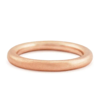 A simple, round, rose gold wedding ring with a smooth finish.