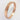 A 9ct rose gold wedding ring with nibbled edges on a white background.
