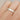 A silver ring with a textured satin finish and burnished edges, featuring a nibbled pattern, worn on a person's finger.