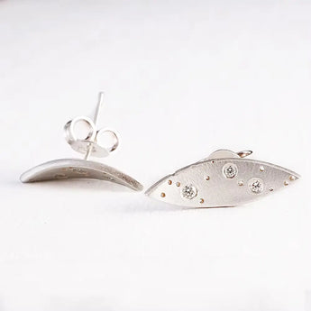 A pair of silver earrings featuring a leaf pattern with three brilliant cut diamonds, set against a white background.