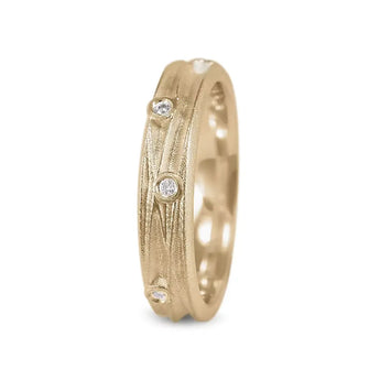 A slim gold ring with scattered diamonds along its surface, featuring a textured design.