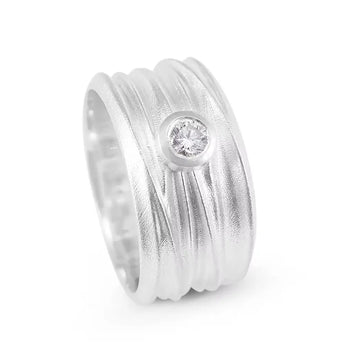 A silver diamond solitaire ring with a textured band and a single brilliant cut diamond stone set in the center.