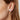 A close-up image of a woman's ear wearing a silver square floral earring with oxidised patterning.