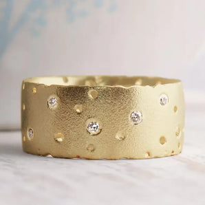 A 9ct gold diamond ring with a frosted finish and brilliant cut diamonds scattered along its surface.