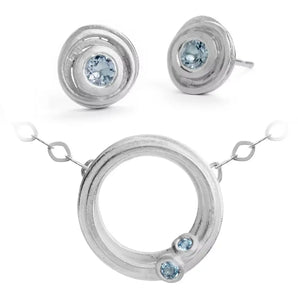 A set of sterling silver jewelry, featuring a swirl necklace and a pair of earrings with ice-cool aquamarines.