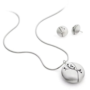 A silver necklace with a floral silhouette pendant accompanied by a pair of matching earrings, displayed against a white background.