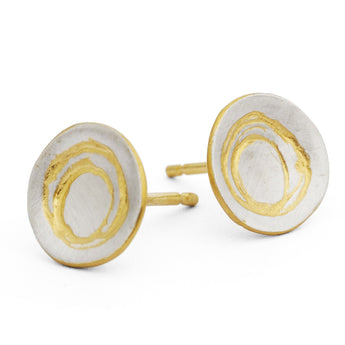 Round silver stud earrings with gold detail design on a white background