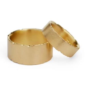 Two 18ct gold wedding rings with nibbled edges and frosted finish, one inside the other.
