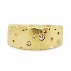 A 18ct yellow gold diamond ring with a textured finish and scattered brilliant cut diamonds set throughout.