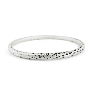 A sterling silver round bangle with a pattern of tiny holes that have been oxidised to create contrast, displayed against a white background.