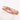 A rose gold ring with a central pink diamond surrounded by a pattern of nibbled marks on a white background.