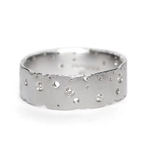 A sterling silver diamond ring with a frosted finish and scattered brilliant cut diamond stones, displayed against a white background.