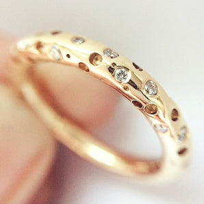 modern gold eternity ring with small diamonds on a light background by Kate Smith Jewellery Birmingham