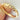 Gold ring with embedded diamonds held by a hand against a neutral background